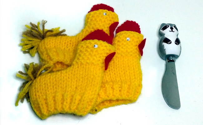 Three knitted chickens and raccoon cheese spreader